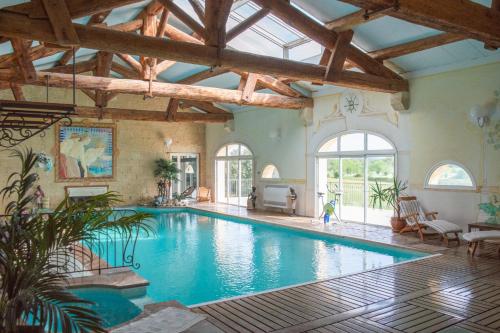 una gran piscina en una habitación con techos de madera en Domaine Mas Bégon, en Aigues-Vives