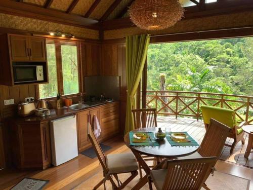 a kitchen and dining room with a table and chairs at Oasis de Tendéa - Bali à Farino in Farino