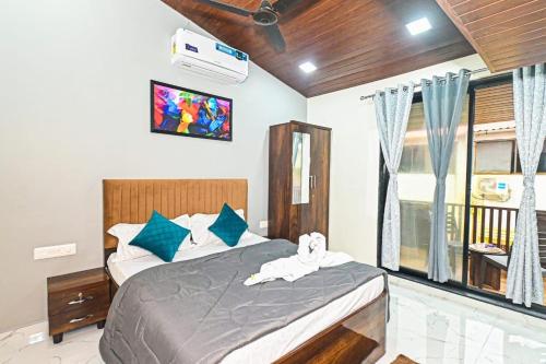 um quarto com uma cama e uma televisão na parede em SK Villa em Āmbavna