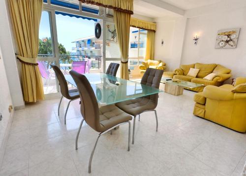 uma sala de jantar com uma mesa de vidro e cadeiras em Skol 439 Spacious and Refurbished Apartment with Sea Views em Marbella