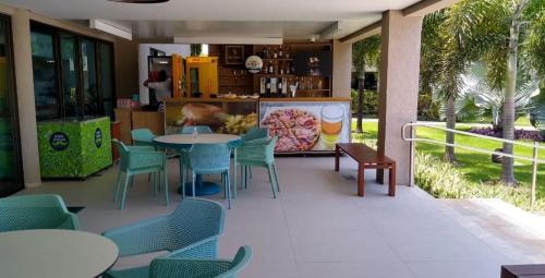 a restaurant with a table and chairs and a counter at Portoparadise - Beach Class Eco life Residence in Porto De Galinhas