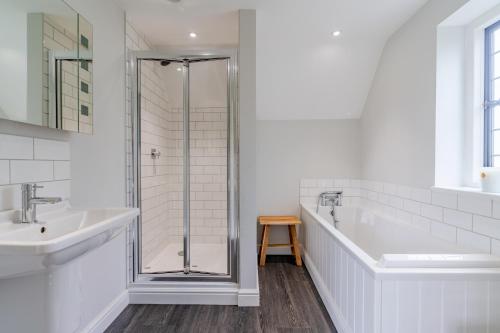 uma casa de banho branca com um chuveiro e um lavatório. em Old Manse em Burford
