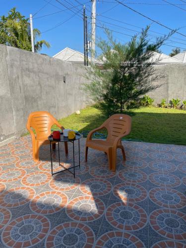 twee stoelen en een tafel op een patio bij Breeze House in Prampuan