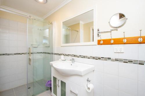 La salle de bains blanche est pourvue d'un lavabo et d'une douche. dans l'établissement Pecan Hill BNB, à Toodyay