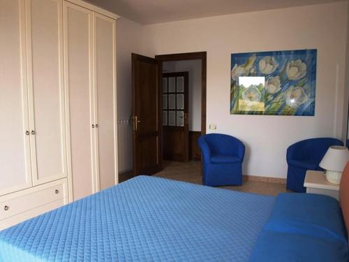 a bedroom with a blue bed and two blue chairs at Casa Passero Orvieto in San Quirico