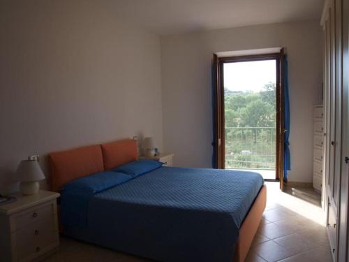 a bedroom with a blue bed and a window at Casa Passero Orvieto in San Quirico