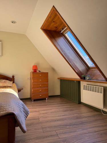 1 dormitorio en el ático con cama y ventana en Danarent Tilto, en Vilna