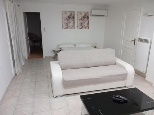 a living room with a white couch and a table at À 10min de la Croisette, bas de Villa Piscine Chauffée in Le Cannet