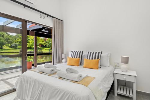 ein Schlafzimmer mit einem großen weißen Bett mit Handtüchern darauf in der Unterkunft San Lameer Villa 1908 - 2 Bedroom Classic - 4 pax - San Lameer Rental Agency in Southbroom