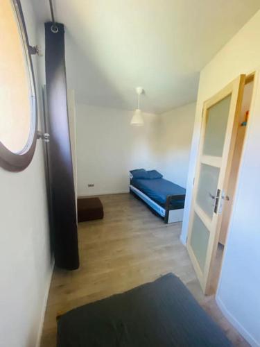 Cette chambre comprend un lit bleu et une porte ouverte. dans l'établissement Le gite du defend, à Salernes