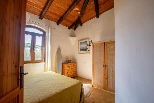 een slaapkamer met een bed en een raam bij Villa Onda in Valledoria