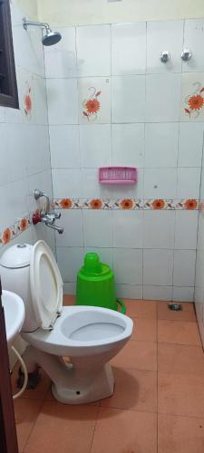 a bathroom with a toilet and a green stool at FLGHR Pc Residency in Kodaikānāl