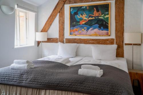 ein Schlafzimmer mit einem großen Bett und einem Gemälde an der Wand in der Unterkunft Brooklyn Penthouse in Kopenhagen