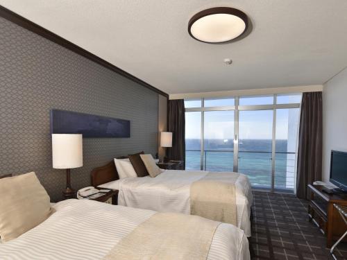 a hotel room with two beds and a large window at Shimoda Prince Hotel in Shimoda