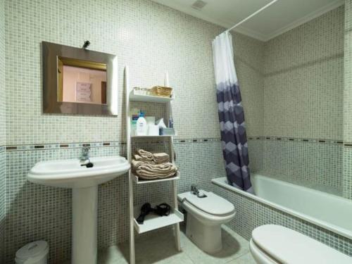 a bathroom with a sink and a toilet and a tub at Reade homes in Luton