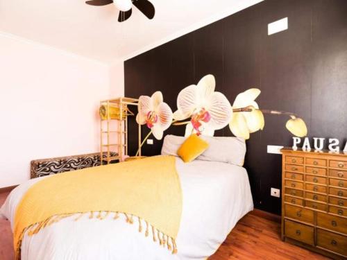 1 dormitorio con 1 cama con flores en la pared en Reade homes en Luton