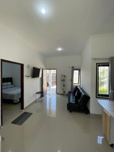 uma sala de estar com um sofá e uma cama em Breeze House em Prampuan