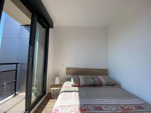 a bedroom with a bed and a large window at La Suite Griffon - Parking & Balcon in Toulouse