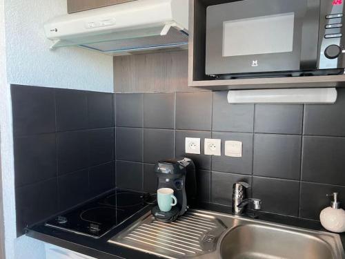 a kitchen with a sink with a coffee maker on it at La Suite Griffon - Parking & Balcon in Toulouse