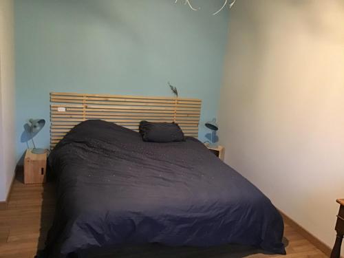 ein Schlafzimmer mit einem Bett mit einer schwarzen Decke in der Unterkunft Apt 2 3 personnes acces jardin 15 min de la mer in Brech
