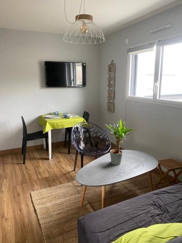 ein Wohnzimmer mit einem Tisch und einem Esszimmer in der Unterkunft Apt 2 3 personnes acces jardin 15 min de la mer in Brech