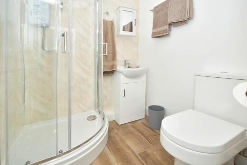 a bathroom with a shower and a toilet and a sink at K Suites - Westport Road in Stoke on Trent