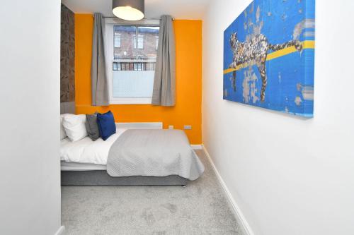 1 dormitorio con paredes de color naranja, 1 cama y ventana en K Suites - Westport Road en Stoke on Trent