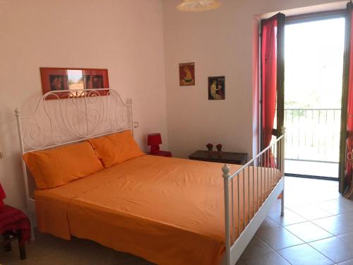 a bedroom with a bed with an orange bedspread at Casa Passero Orvieto in San Quirico