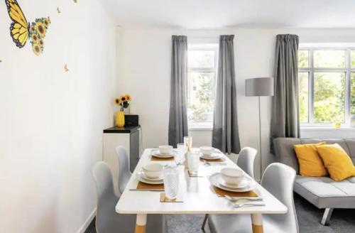 een witte eetkamer met een witte tafel en stoelen bij K Suites - Harboro Grove in Sale