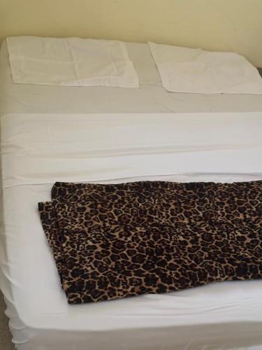 a bed with a leopard print blanket on it at Darius Adefon in Nouakchott