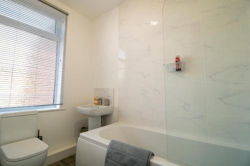 Baño blanco con bañera y lavamanos en K Suites - Carr Hill Road en Gateshead