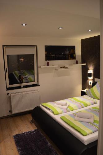 a bedroom with a large bed with green and yellow pillows at SinueSsa in Cologne