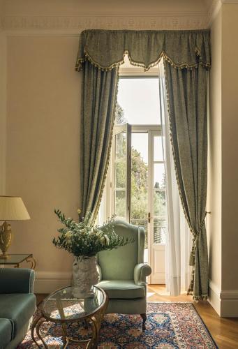 a living room with a chair and a window at Grand Hotel Timeo, A Belmond Hotel, Taormina in Taormina