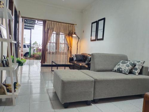 a living room with a couch and a chair at Argolawu Homestay in Tawangmangu