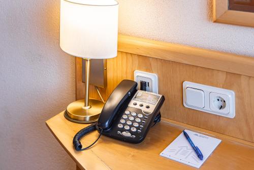 un teléfono sentado en un escritorio en una habitación de hotel en Ringberg Hotel, en Suhl