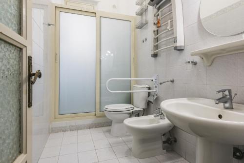 La salle de bains est pourvue de toilettes, d'un lavabo et d'un miroir. dans l'établissement Tera & Turi House by Wonderful Italy, à Catane
