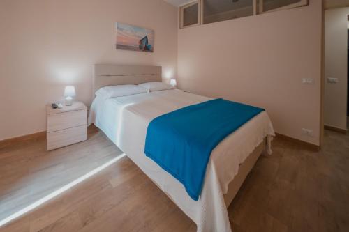 a bedroom with a bed with a blue blanket on it at Uno Scorcio sulla Rocca by Wonderful Italy in Cefalù