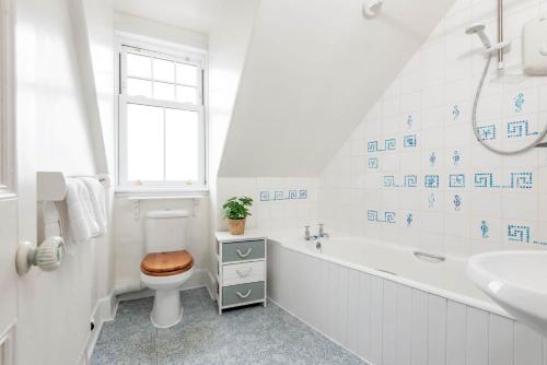 a white bathroom with a toilet and a sink at Braeside - 4 Beds - Sleeps 8 - Garden in St Andrews