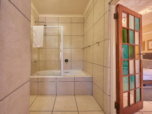 a bathroom with a tub and a shower stall at 84 on Fourth Guest House in Johannesburg