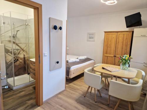 een kleine kamer met een tafel en een slaapkamer bij Winzerhof Lentsch in Jois
