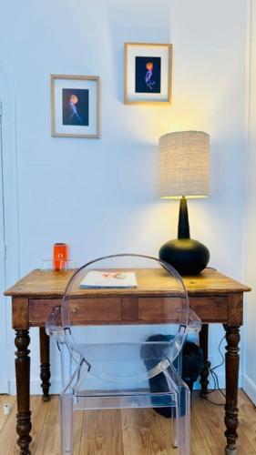 a desk with a lamp and a glass chair at Hotel L'Océan in Le Bois-Plage-en-Ré