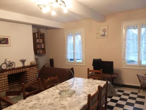 un soggiorno con tavolo e camino di maison des papillons a Tourville-la-Chapelle