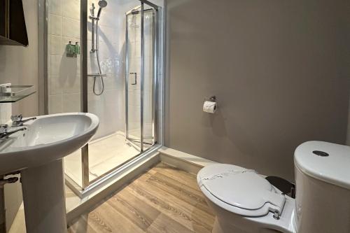 a bathroom with a shower and a toilet and a sink at The Lobster in Sheringham