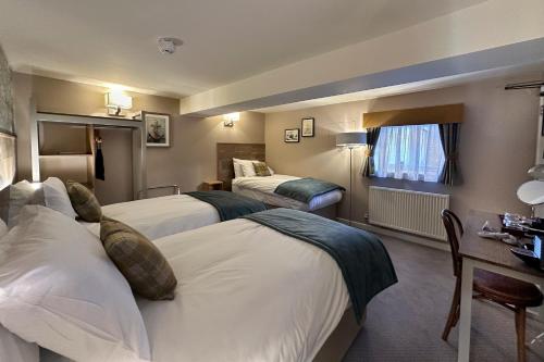 a hotel room with two beds and a desk at The Lobster in Sheringham