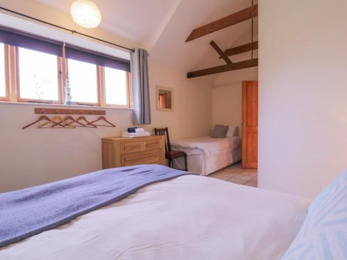 a bedroom with a bed and a window at Avocet Cottage in Saxmundham