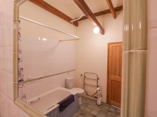 a bathroom with a tub and a toilet at Avocet Cottage in Saxmundham
