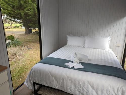 a bed with a towel and a stuffed animal on it at Tiny House 14B at Grampians Edge in Dadswells Bridge