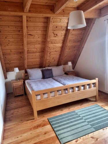 a bedroom with a bed in a wooden ceiling at Ferienwohnung Metzner Harnsbach in Burgebrach