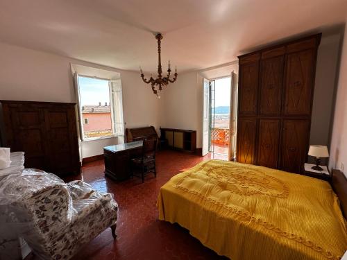 Villa San Giorgio vista mare Alassio في ألاسيو: غرفة نوم بسرير وكرسي ونوافذ
