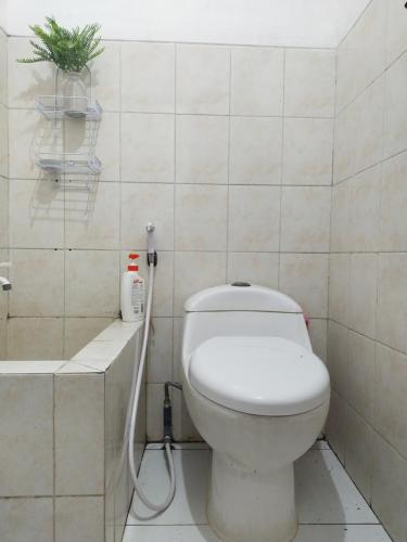 a bathroom with a white toilet and a bath tub at Argolawu Homestay in Tawangmangu